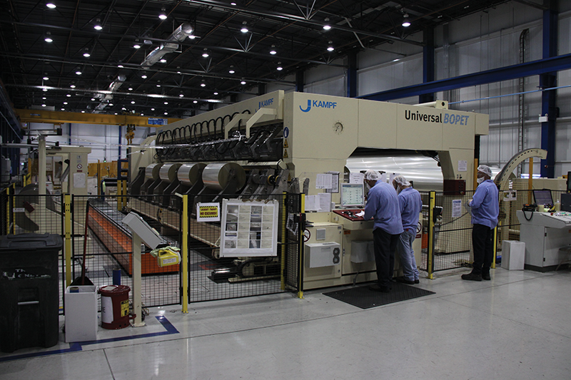 Workers at the $130 million Flex Films USA manufacturing plant in Elizabethtown prepare equipment to apply finishing processes to plastic film that will become product packaging. The Indian owned company expects work to add a second production line to begin some time in 2015.